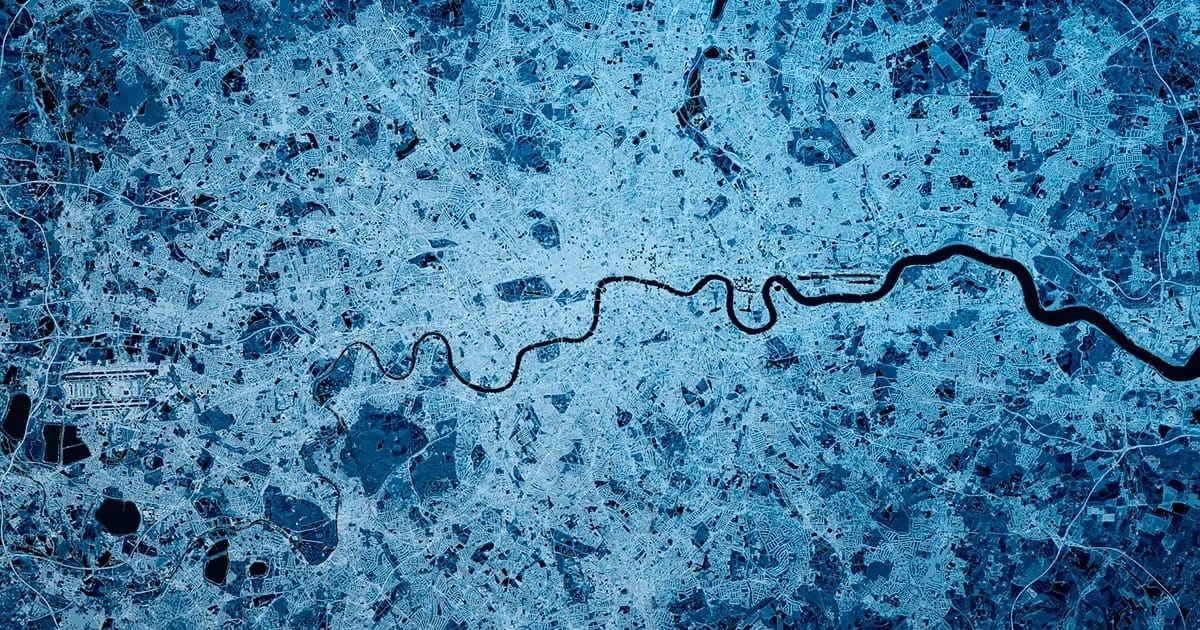 An abstract photograph in different blue hues with a dark navy squiggle representing the river