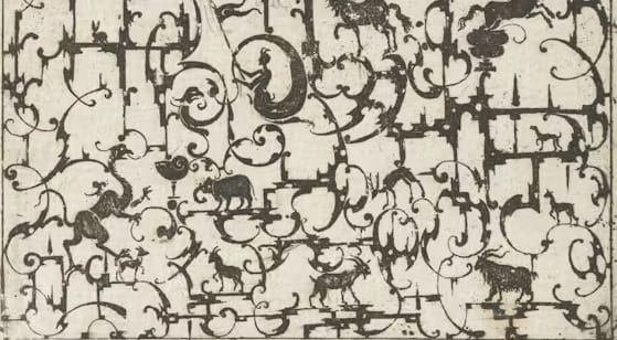 a black and white decorative scrollwork image with animals