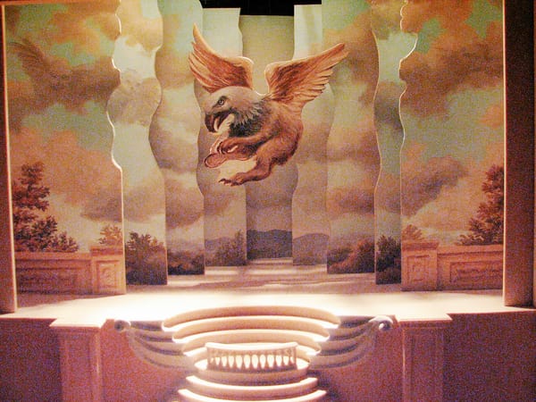 A photo of a miniature stage with a pastoral scent and a gryphon flying over the stage